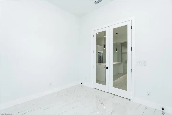 Spare room featuring french doors and light marble finish flooring