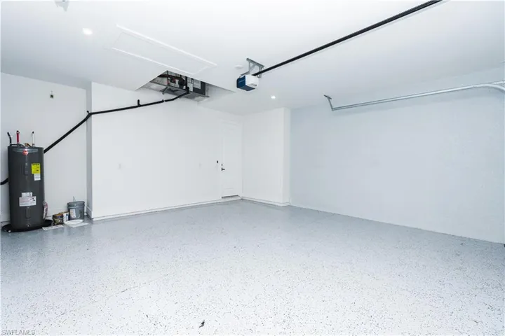 Garage featuring water heater and a garage door opener