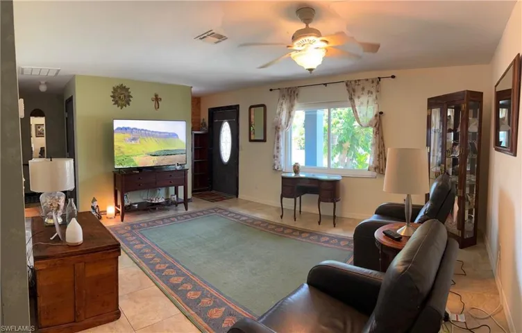 Living room featuring light tile patterned flooring and a ceiling fan