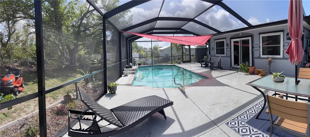 Swimming pool featuring glass enclosure and a patio area