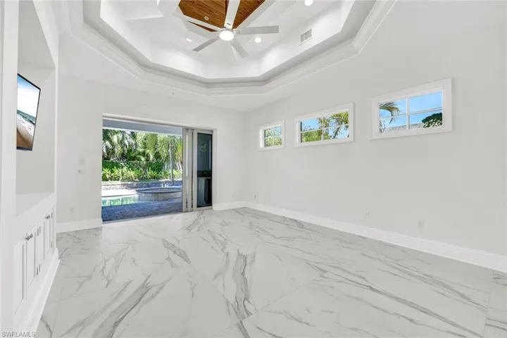 Spacious primary guest suite with sliding door to back lanai and pool area