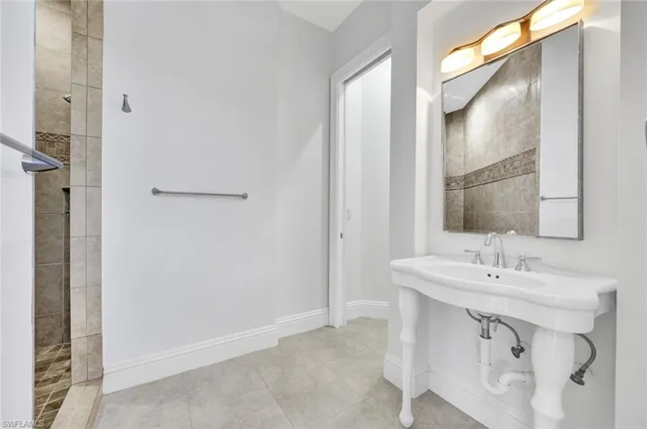 Middle guest-bathroom with walk in shower and vanity sink.