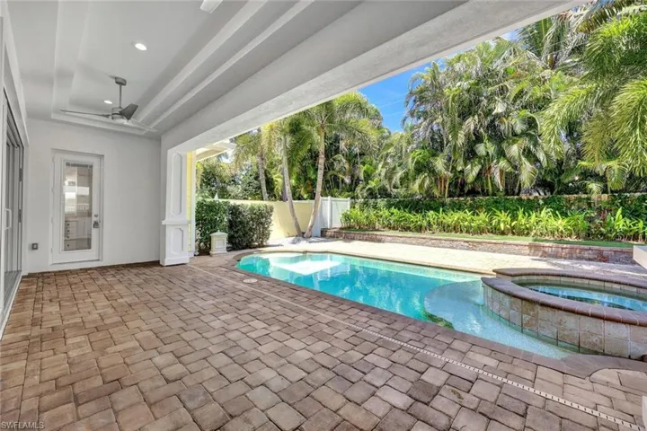 View of pool featuring a fenced backyard, a patio area, and a pool with connected hot tub