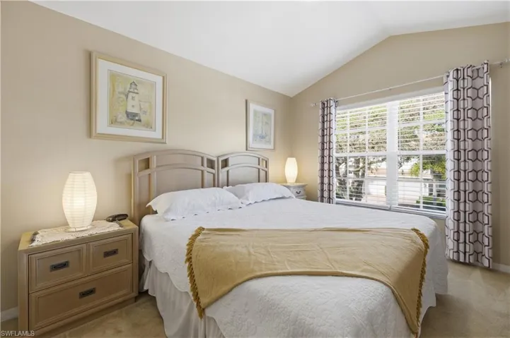 Bedroom featuring carpet flooring and vaulted ceiling