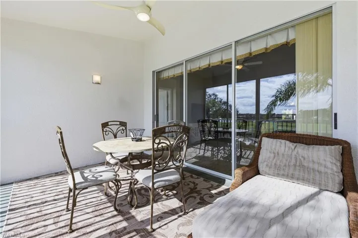 Sunroom with ceiling fan, outdoor dining space, and a patio