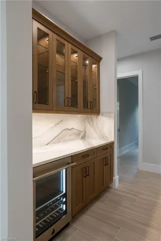 Bar featuring wine cooler and wood tiled floors