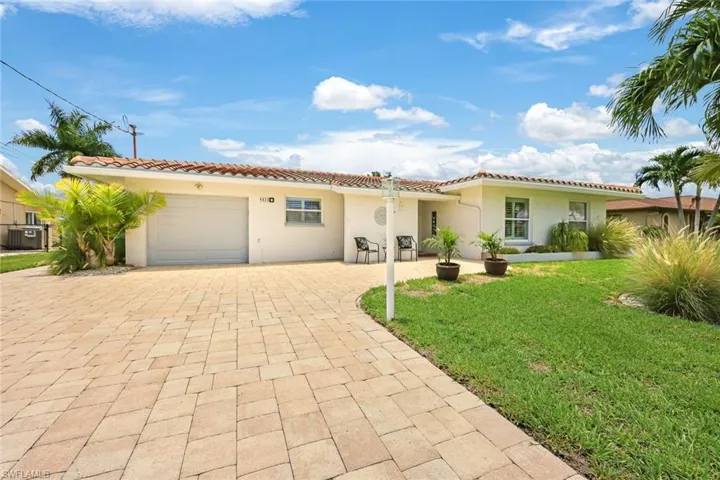 Mediterranean / spanish-style house with a garage, a front yard, and central AC unit