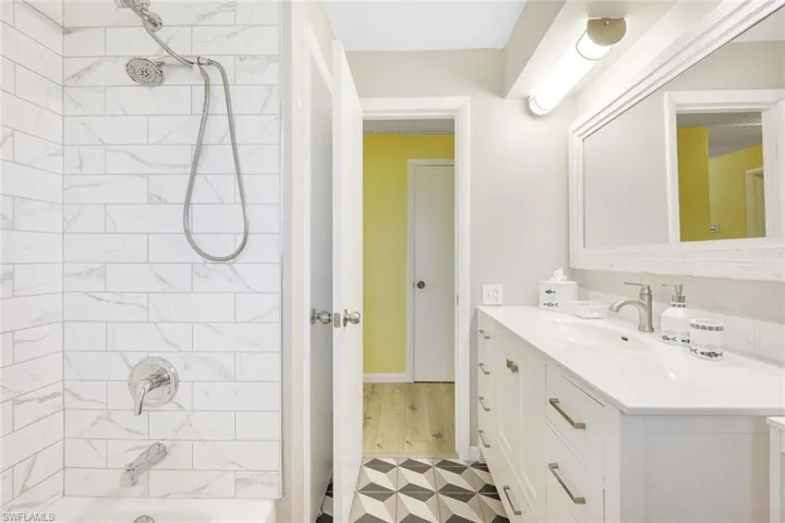 Bathroom with tiled shower / bath, oversized vanity, and tile flooring
