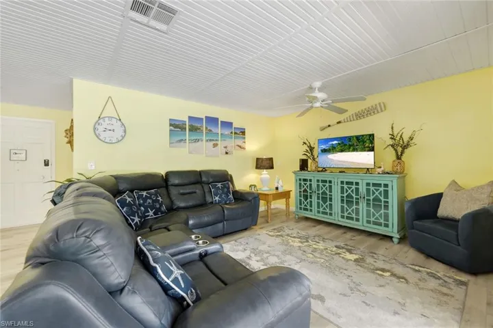 Living room with ceiling fan and hardwood / wood-style flooring
