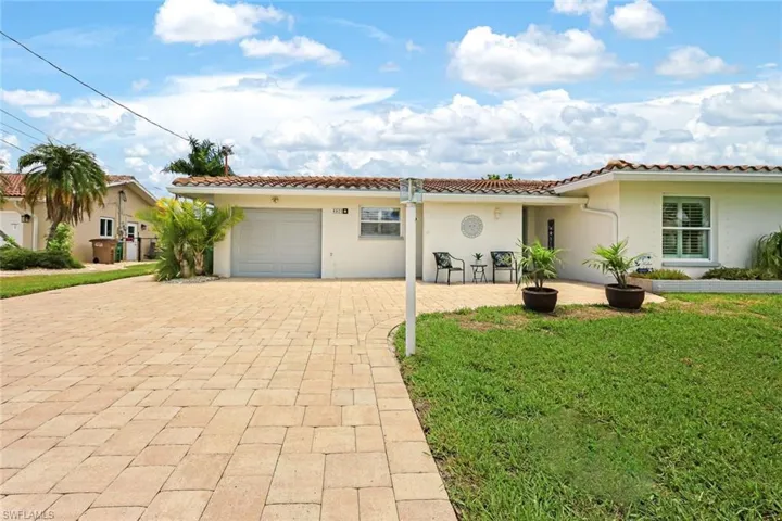 Mediterranean / spanish house with a garage and a front lawn