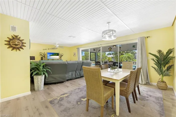 Dining room featuring light wood-type flooring and ceiling fan with notable chandelier
