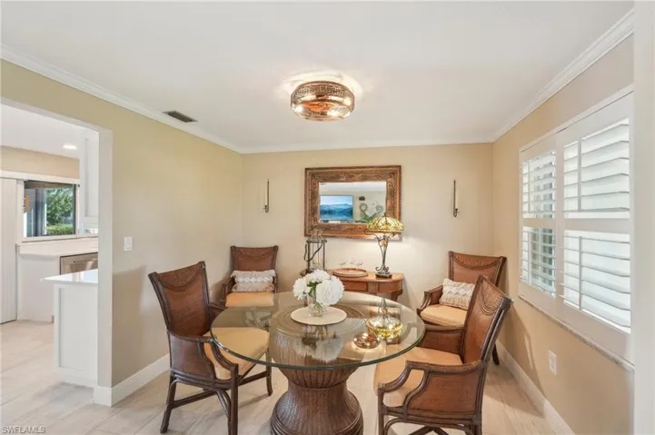 Dining space with light hardwood / wood-style flooring and ornamental molding
