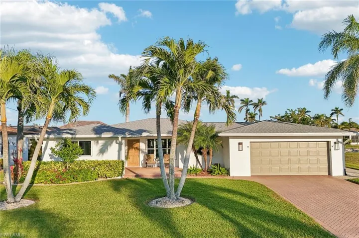 Single story home featuring a garage and a front yard