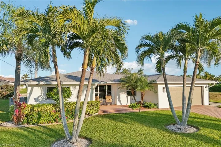 View of front of house with a garage and a front lawn