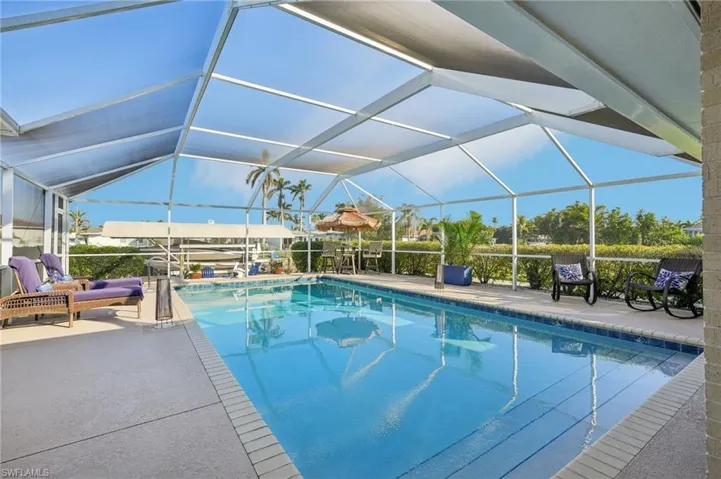 View of swimming pool featuring a patio and glass enclosure