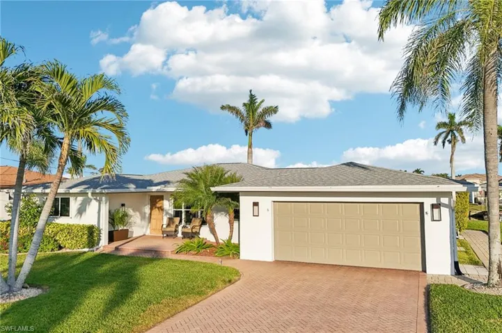 Single story home featuring a garage and a front yard