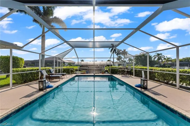 View of swimming pool featuring a patio area and glass enclosure