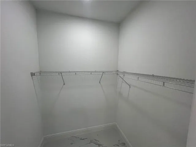 Master walk in closet with marble finish flooring