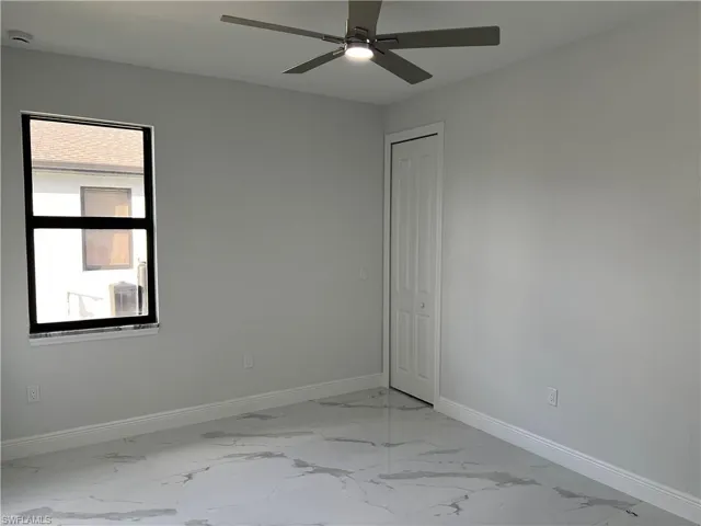Bedroom 3 featuring light marble finish floors and ceiling fan