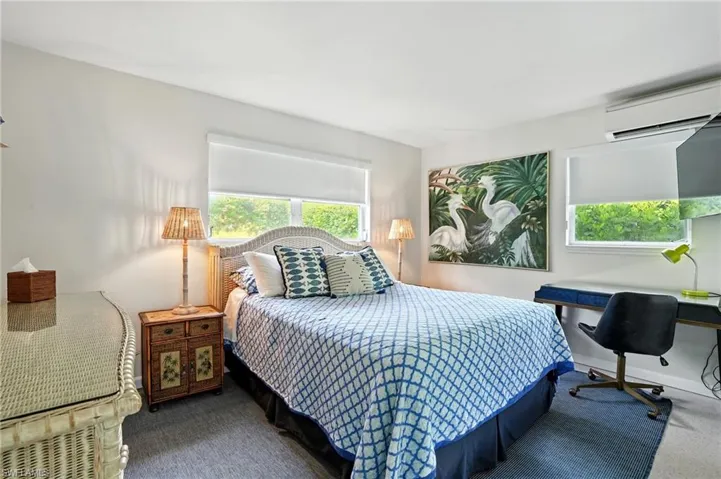 Bedroom featuring a wall mounted AC and carpet flooring
