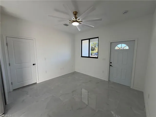 Entrance foyer featuring ceiling fan and light marble finish flooring