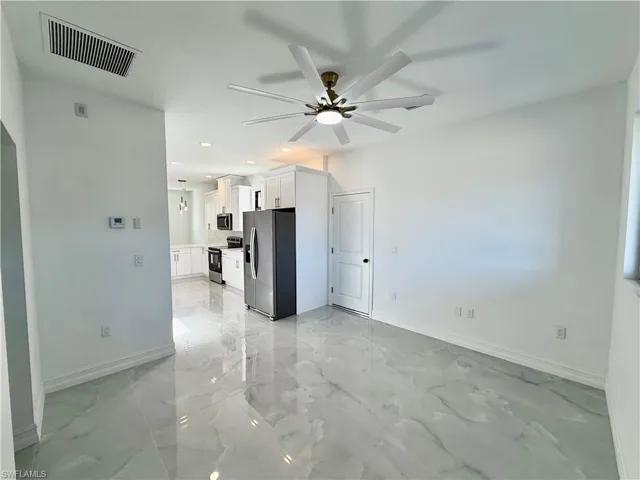 Unfurnished living room featuring ceiling fan, light marble finish floors, and recessed lighting