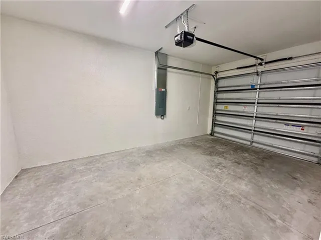 Garage featuring a garage door opener and electric panel