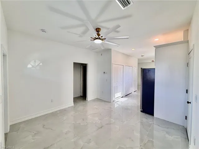 Spare room with ceiling fan, light marble finish flooring, and recessed lighting