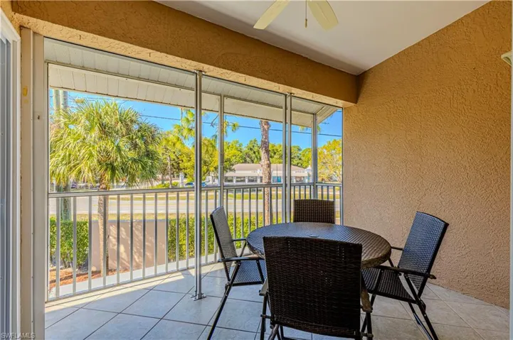 Screened patio w/ balcony, outdoor dining area & ceiling fan.