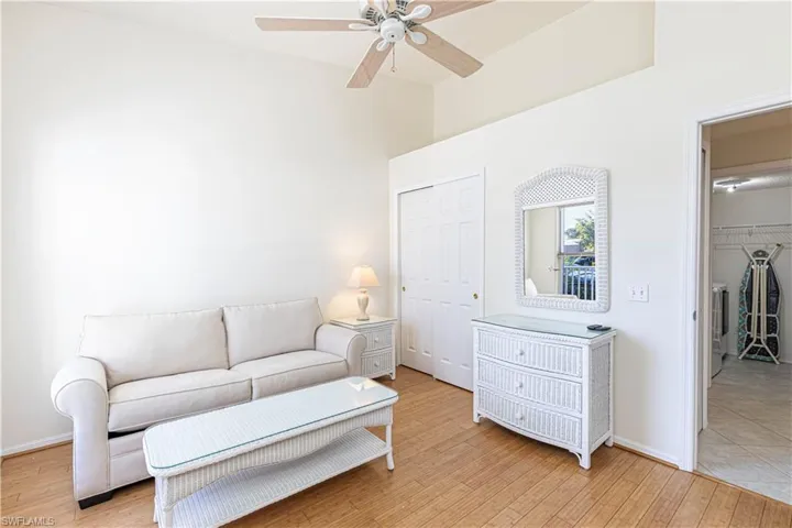 Guest bedroom w/ light wood-style flooring & ceiling fan.