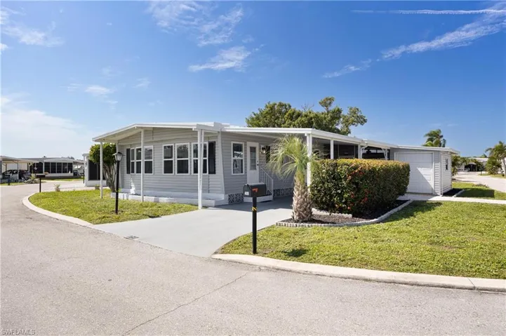 Manufactured / mobile home with a front yard and a garage