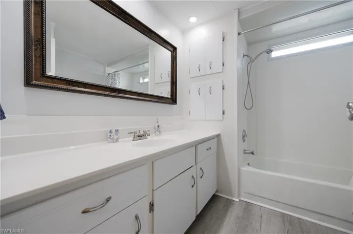 Bathroom featuring vanity, bathtub / shower combination, and hardwood / wood-style floors