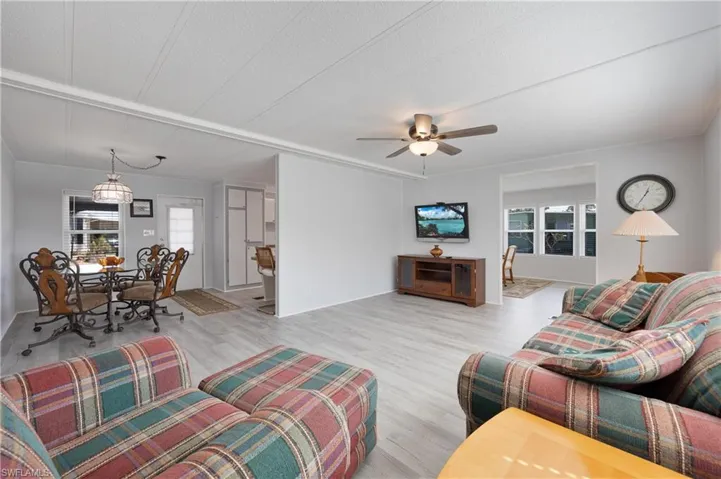 Living room featuring light hardwood / wood-style flooring, a textured ceiling, and ceiling fan