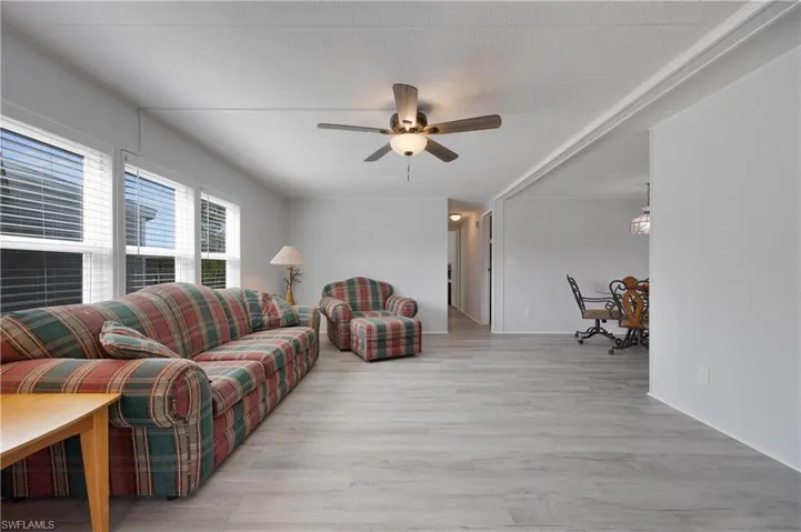Living room with light hardwood / wood-style floors and ceiling fan