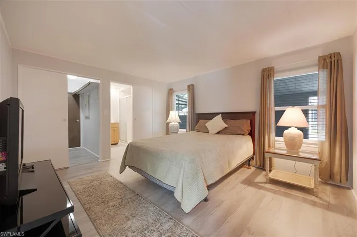 Bedroom with connected bathroom, a closet, and light hardwood / wood-style floors