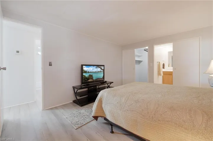 Bedroom featuring ensuite bathroom and light hardwood / wood-style flooring