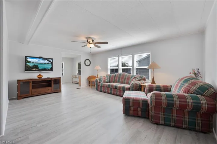 Living room featuring light hardwood / wood-style floors, a textured ceiling, and ceiling fan