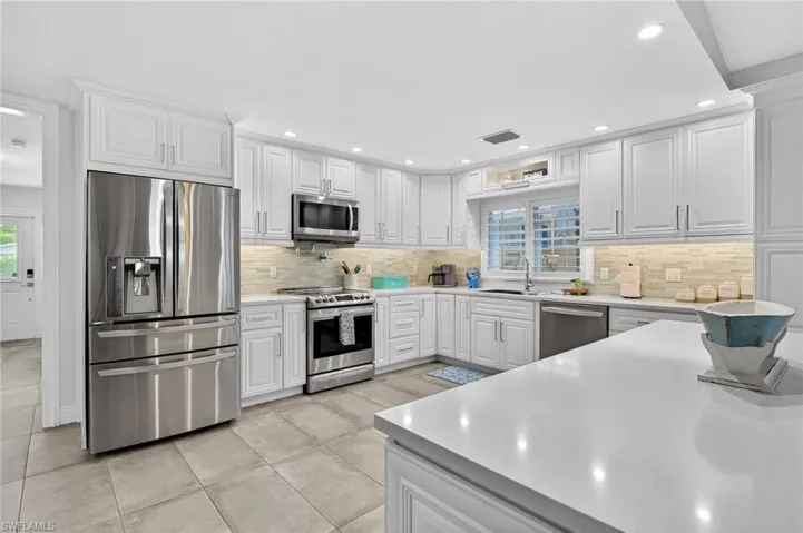 Kitchen featuring stainless steel appliances, white cabinetry, healthy amount of natural light, and recessed lighting