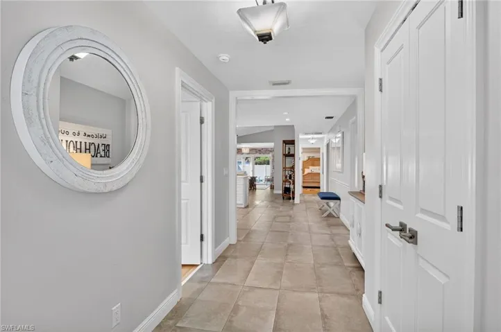 Hallway featuring baseboards and light tile patterned flooring