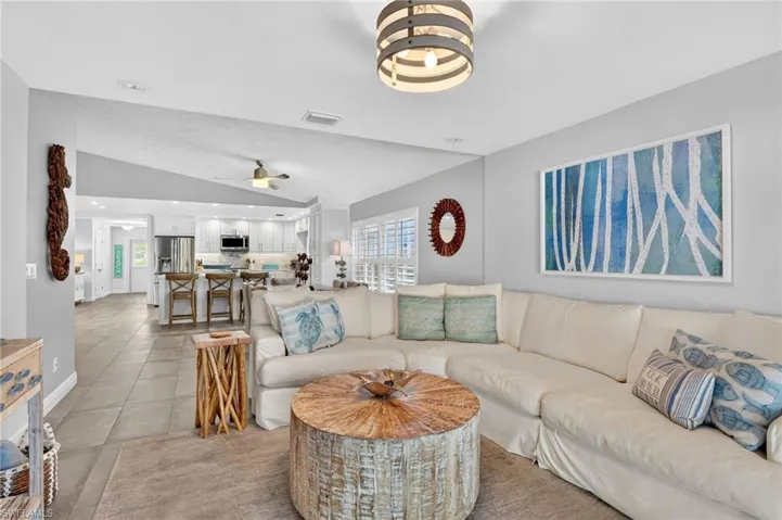 Living area with vaulted ceiling, a chandelier, recessed lighting, and light tile patterned floors
