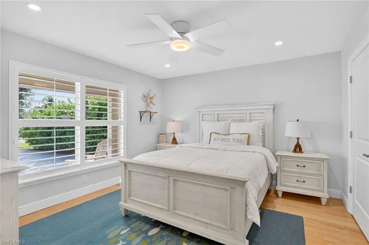 Bedroom with light wood-style flooring, ceiling fan, and recessed lighting