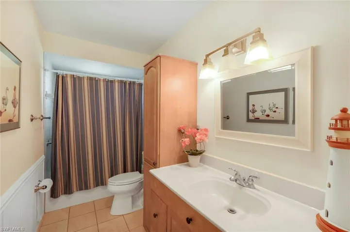Bathroom with tub & shower combination with patterned tile flooring