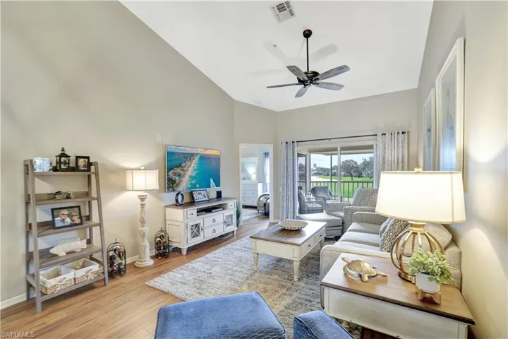 Living area with light wood-type flooring, ceiling fan, and lofted ceiling