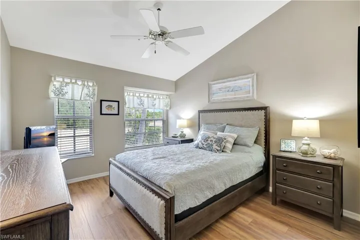 Bedroom with wood finished floors, lofted ceiling, and ceiling fan