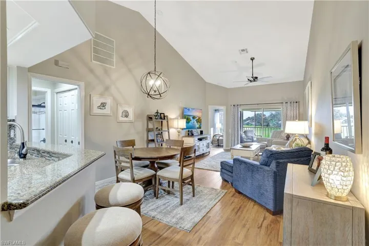 Dining space with light wood-style floors, high vaulted ceiling, and a ceiling fan