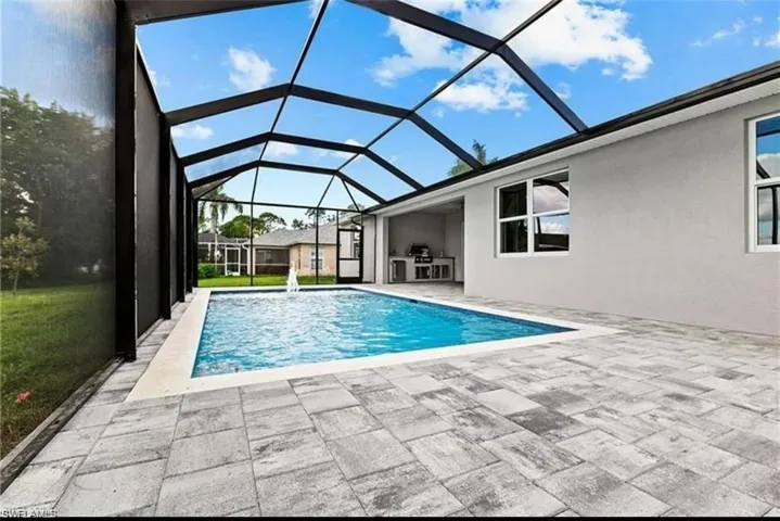 Swimming pool featuring a sunroom, a lanai, and a patio