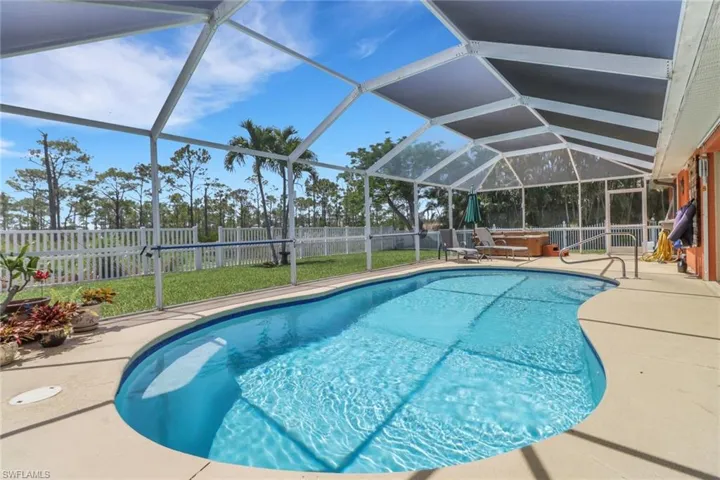 View of pool featuring a fenced backyard, a patio area, hot tub, and a lanai