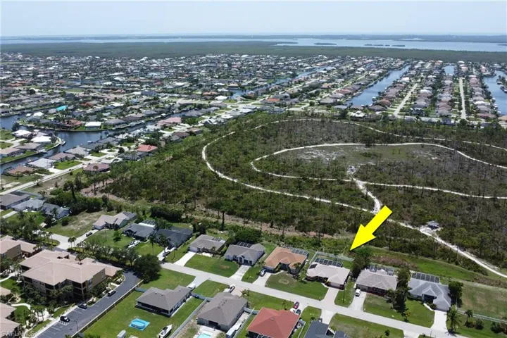 Amazing aerial view of the home, Joe Coviello Park, and surrounding region featuring the nearby canals, neighborhood, local waters connected to the Gulf, and Pine Island