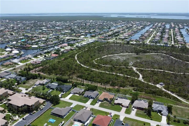 Outstanding aerial view of the home, Joe Coviello Park, and surrounding region featuring the nearby canals, neighborhood, local waters connected to the Gulf, and Pine Island