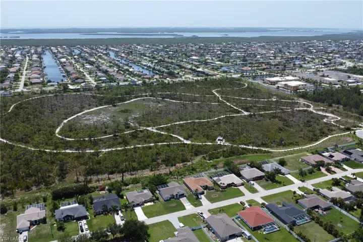 Breathtaking aerial view of the home, Joe Coviello Park, and surrounding region featuring the neighborhood, local waters connected to the Gulf, and Pine Island
